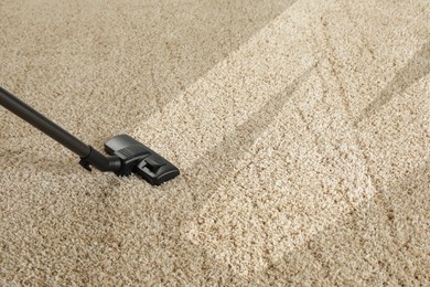 Hoovering carpet with vacuum cleaner, space for text. Clean trace on dirty surface