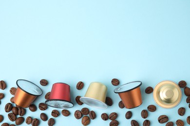 Photo of Many coffee capsules and beans on light blue background, flat lay. Space for text