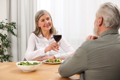 Happy senior couple having romantic dinner at home