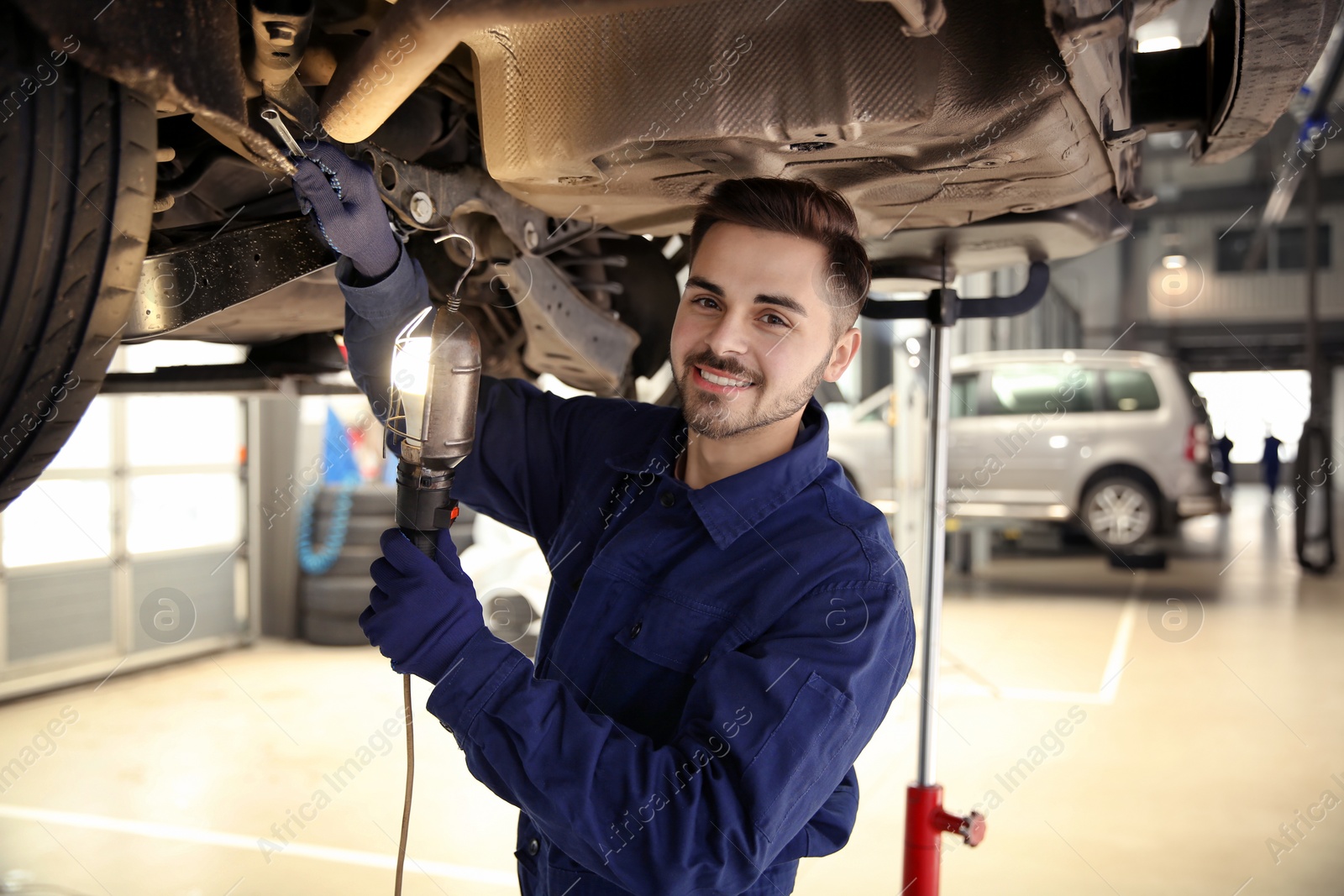 Photo of Technician checking modern car at automobile repair shop