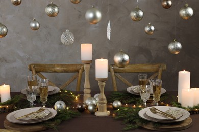 Christmas table setting with burning candles and festive decor