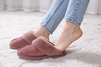 Photo of Woman in soft slippers at home, closeup