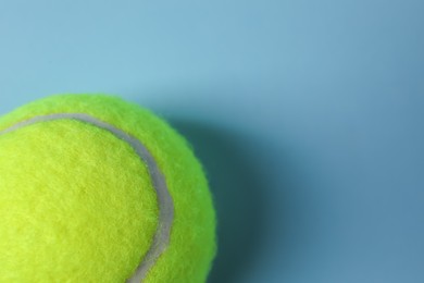 Photo of One tennis ball on light blue background, top view. Space for text