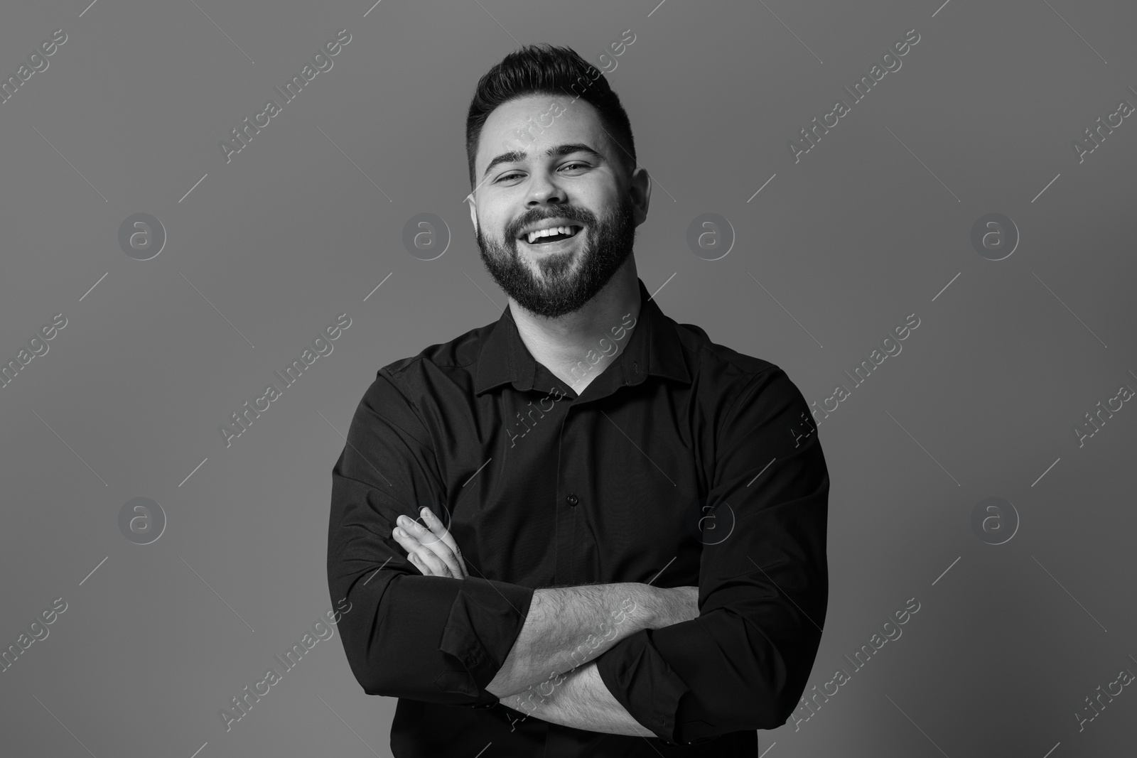 Photo of Portrait of handsome bearded man on grey background. Black and white effect