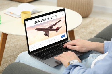 Image of Woman using laptop to book flight at home, closeup