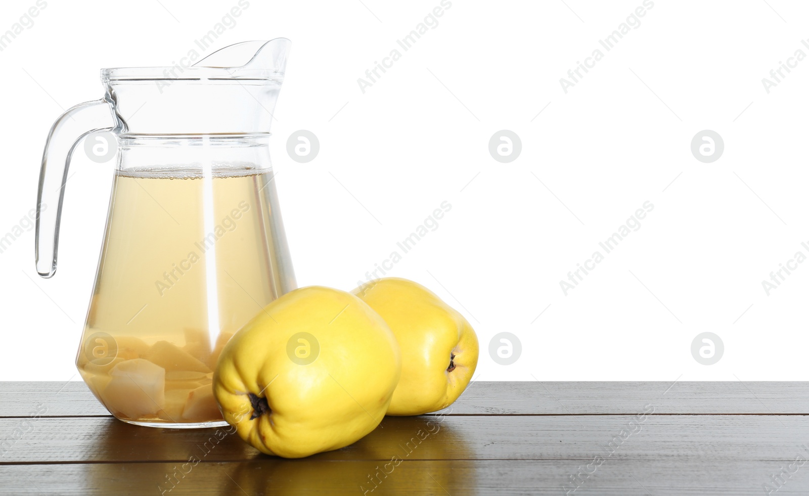 Photo of Delicious quince drink and fresh fruits on wooden table against white background