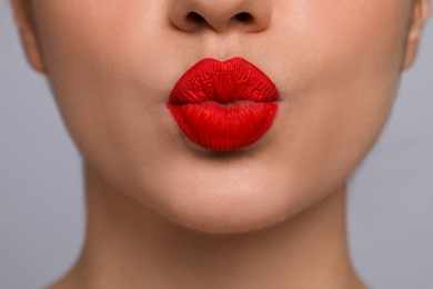 Photo of Closeup view of beautiful woman puckering lips for kiss	on grey background