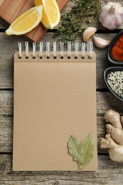 Blank recipe book and different ingredients on old wooden table, flat lay. Space for text