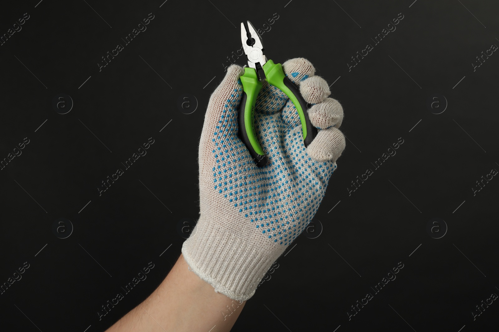 Photo of Man with combination pliers on black background, closeup