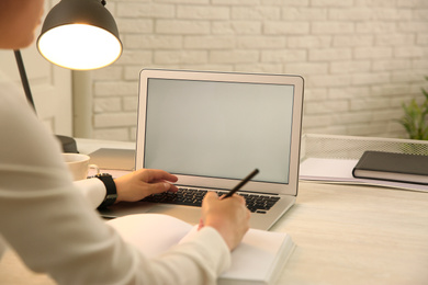 Woman working with modern laptop at white table, closeup. space for design