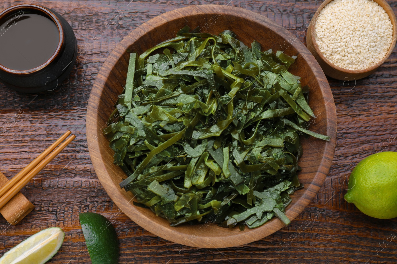 Photo of Fresh laminaria (kelp) seaweed served on wooden table, flat lay