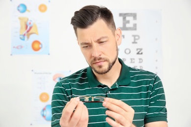 Photo of Young man with glasses visiting ophthalmologist