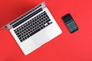 Photo of Modern laptop and mobile phone on color background, top view