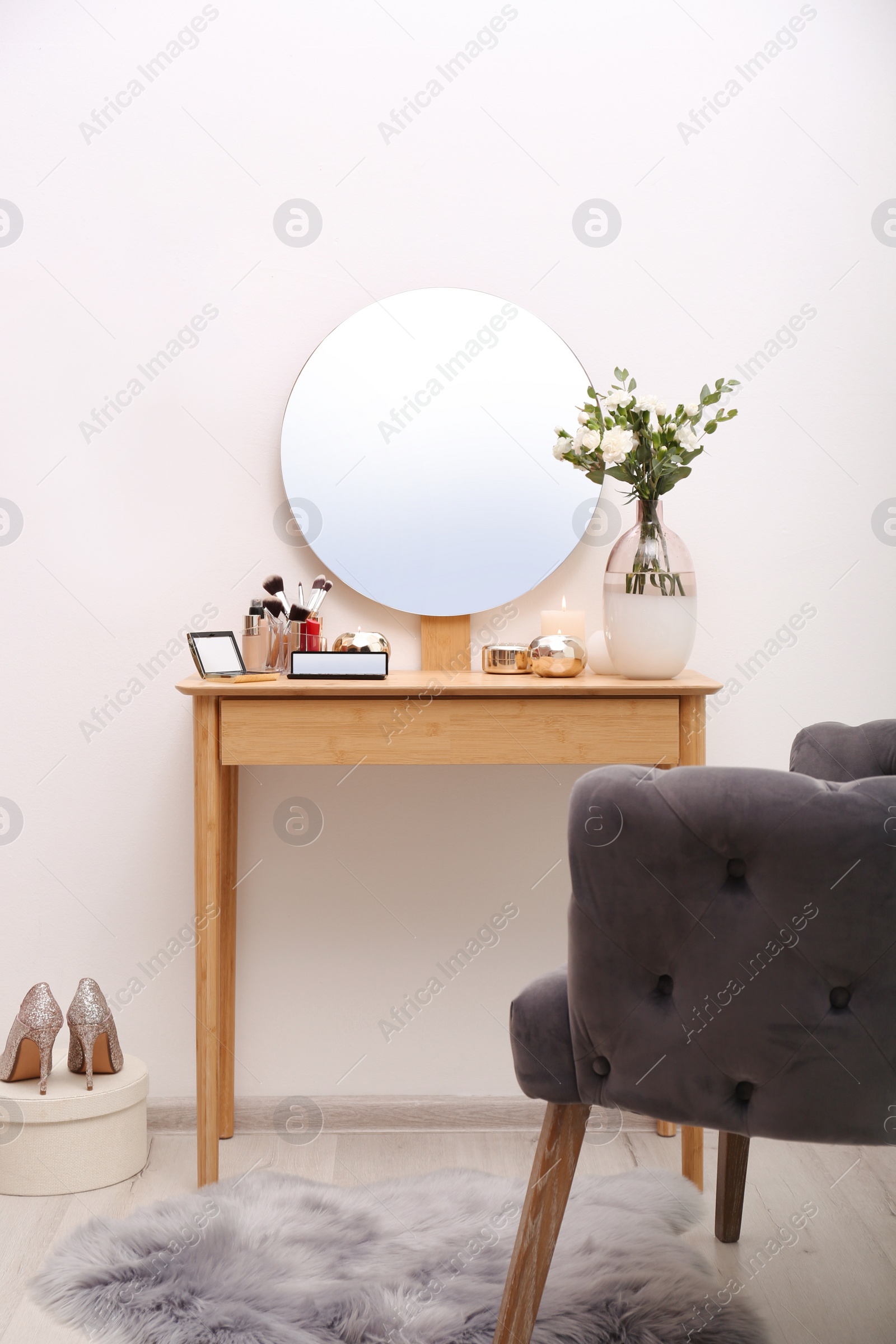 Photo of Stylish room interior with wooden dressing table and armchair