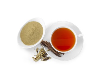 Aromatic licorice tea in cup, dried sticks of licorice root and powder on white background, top view