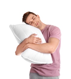 Photo of Young man in pajamas embracing pillow on white background