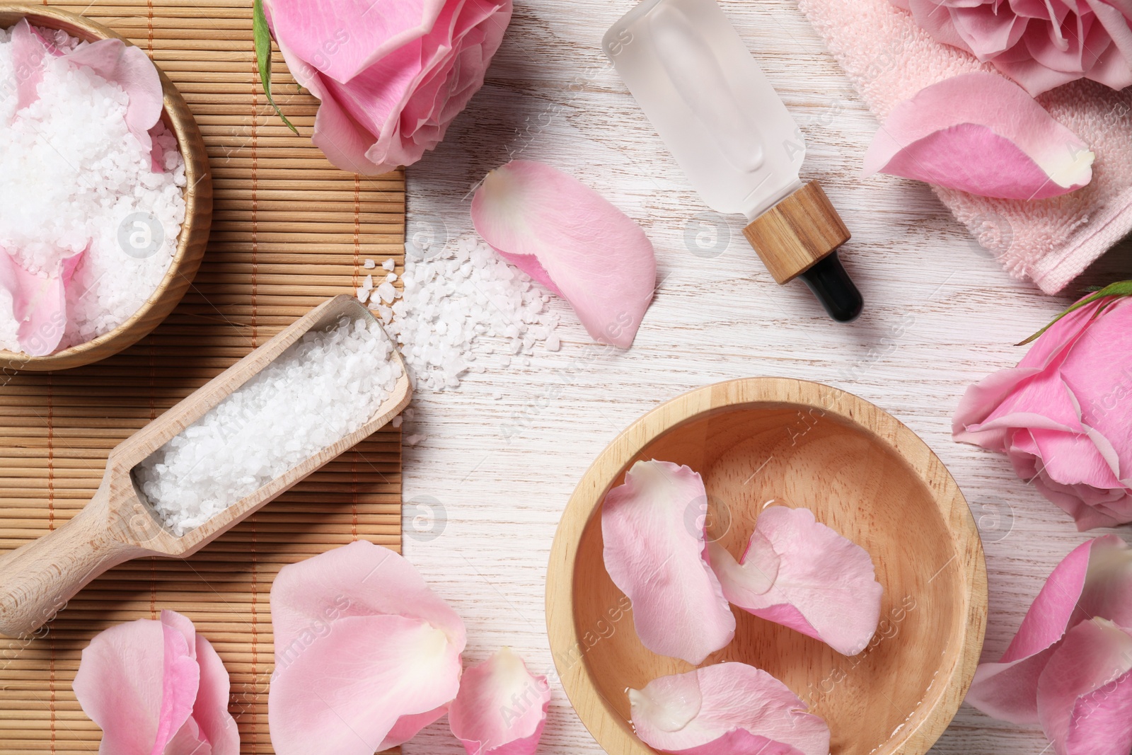 Photo of Flat lay composition with sea salt and beautiful petals of roses on white wooden table