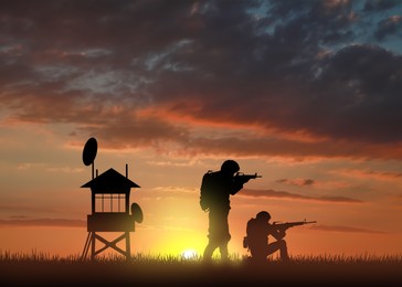 Image of Silhouettes of border guards at post outdoors in evening