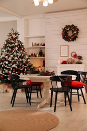 Photo of Cozy dining room interior with Christmas tree and festive decor