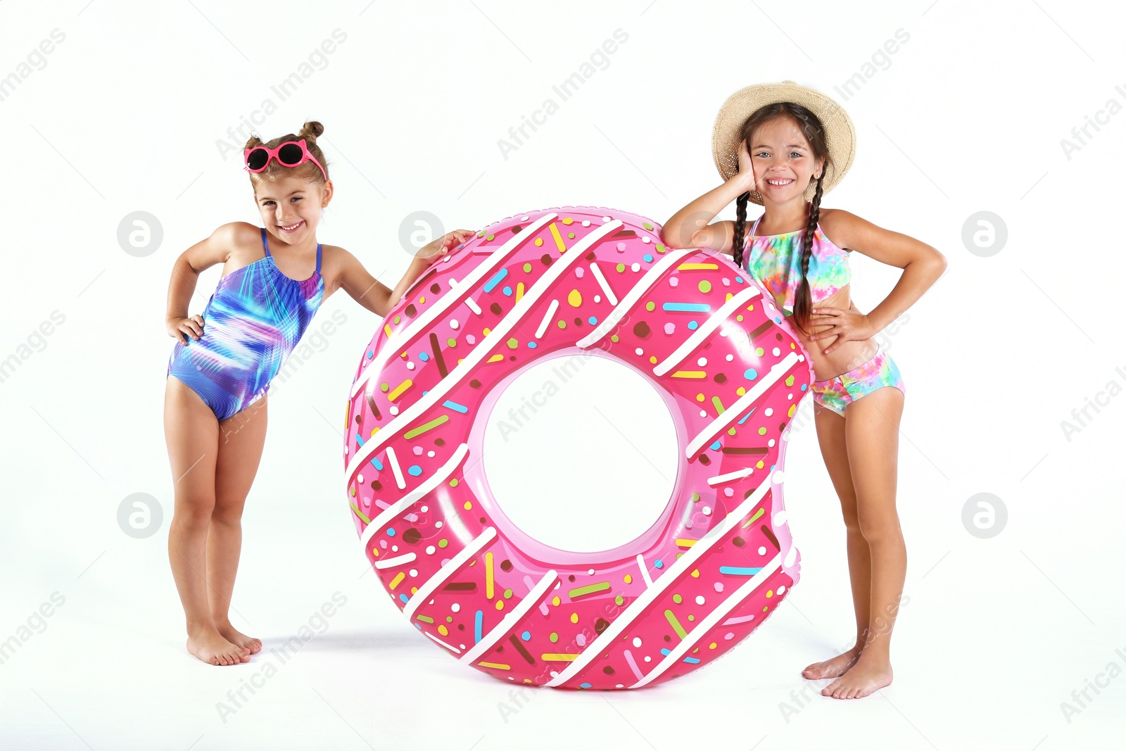 Photo of Cute little children in beachwear with bright inflatable ring on white background