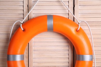 Photo of Orange lifebuoy on wooden background. Rescue equipment