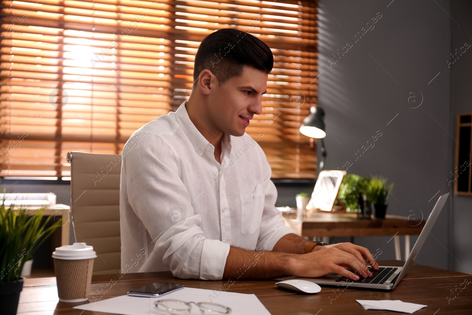 Photo of Freelancer working on laptop at table indoors