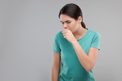 Photo of Woman coughing on grey background, space for text. Cold symptoms