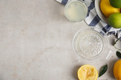 Photo of Glass squeezer with juice and lemons on light table, flat lay. Space for text