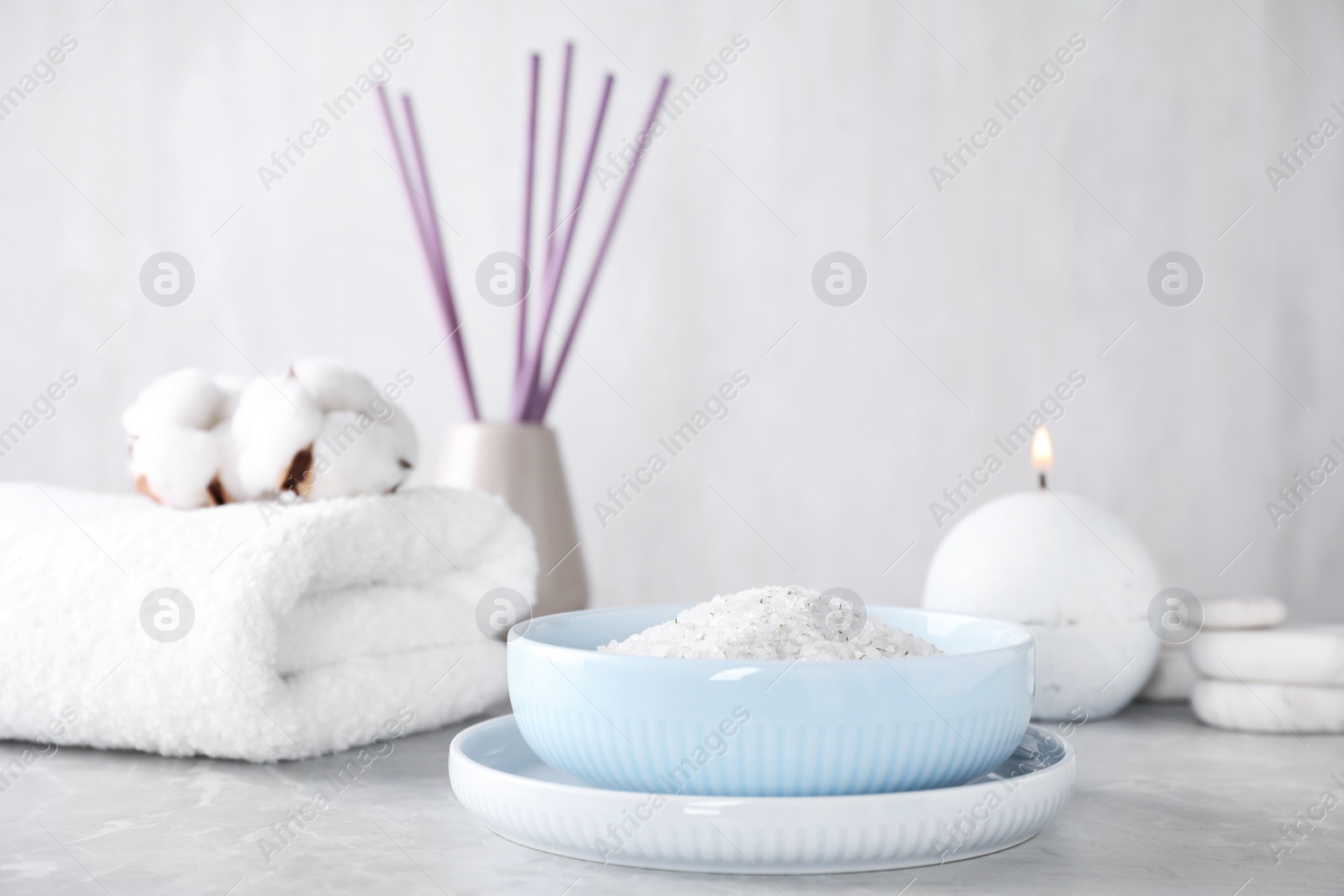 Photo of White sea salt for spa scrubbing procedure on grey marble table