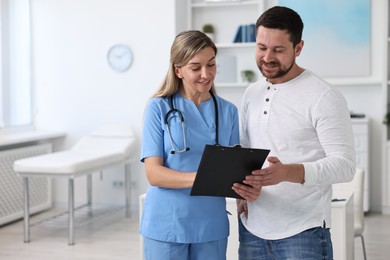 Photo of Professional doctor working with patient in hospital, space for text