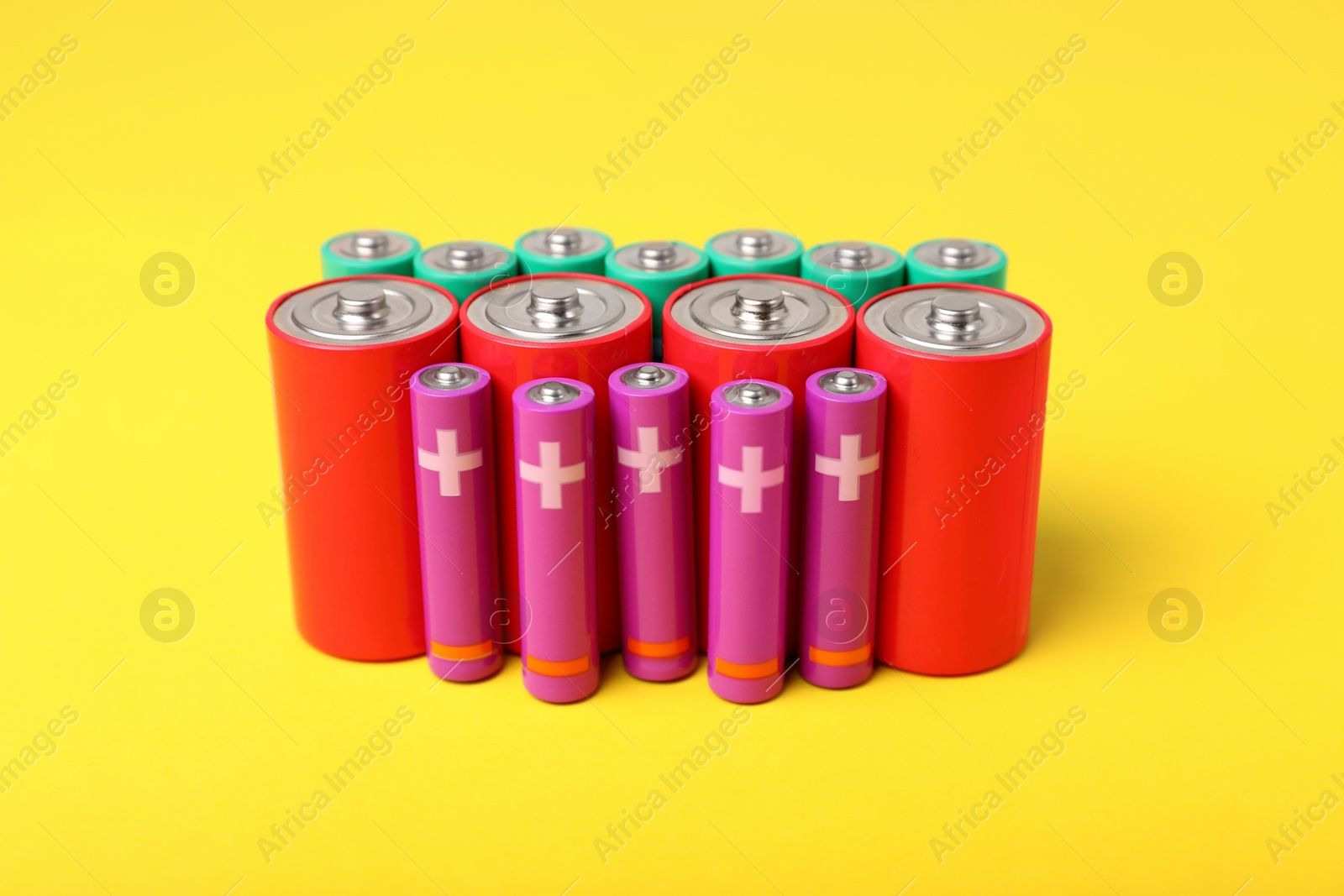 Photo of Batteries of different sizes on yellow background