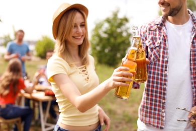 Photo of Young people with bottles of beer outdoors. Summer picnic