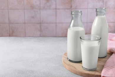 Photo of Glassware with tasty milk on light table, space for text