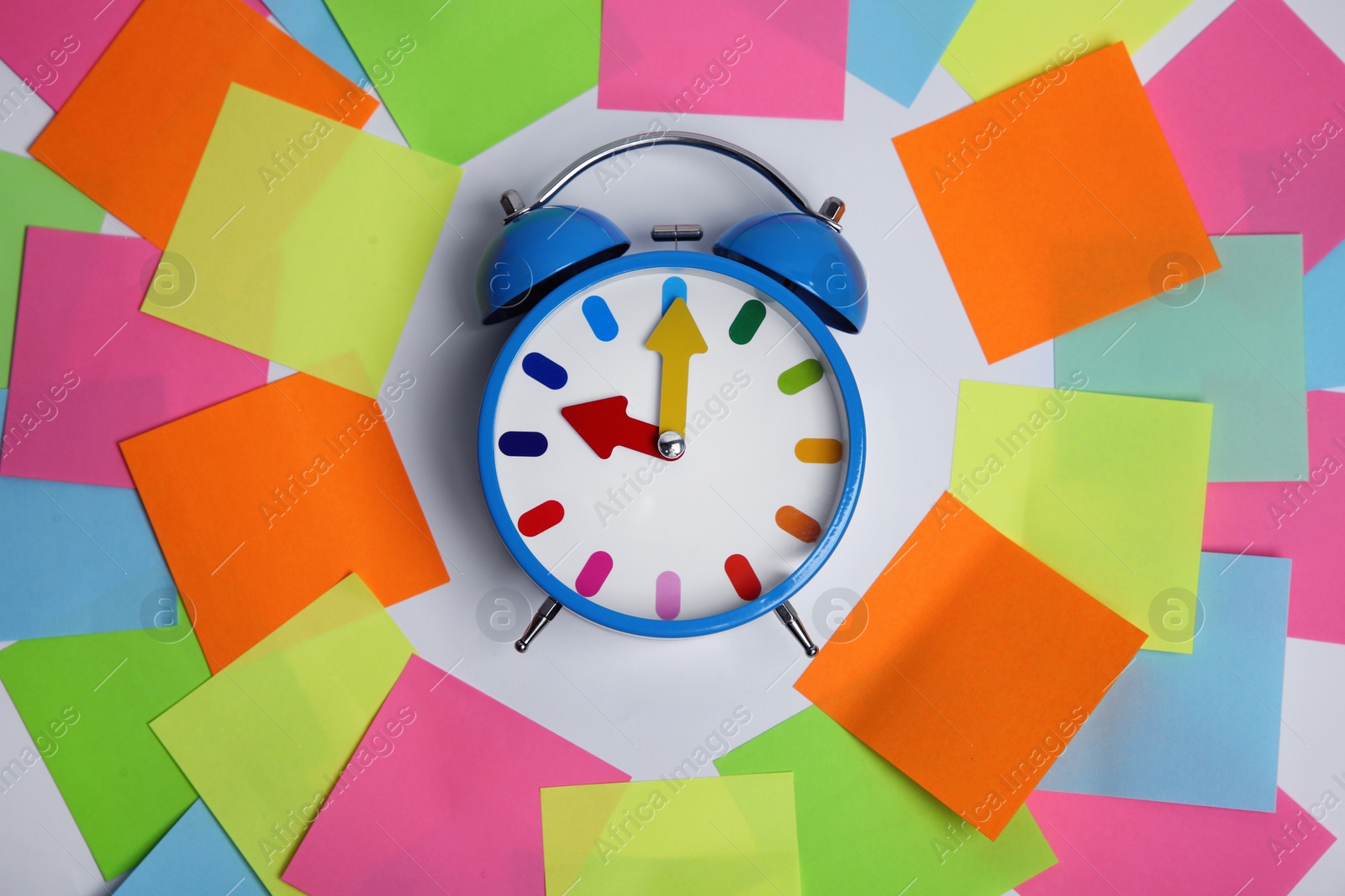 Photo of Alarm clock and reminder notes on light background, flat lay. Space for text