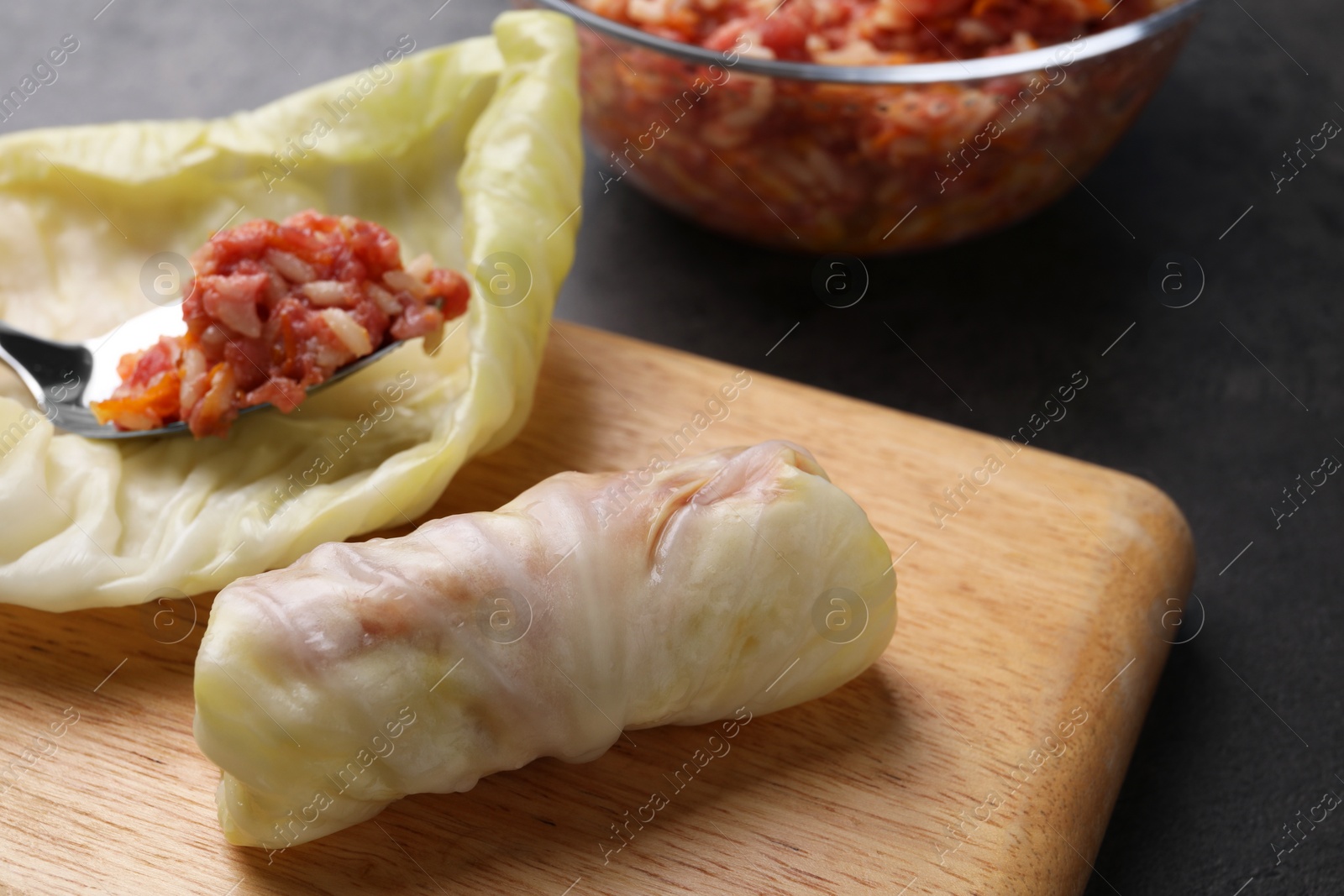 Photo of Preparing stuffed cabbage rolls on table, closeup