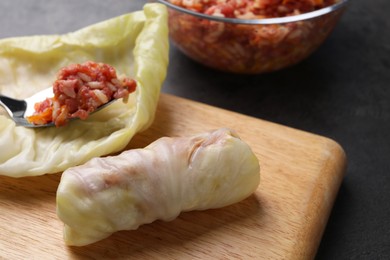 Photo of Preparing stuffed cabbage rolls on table, closeup