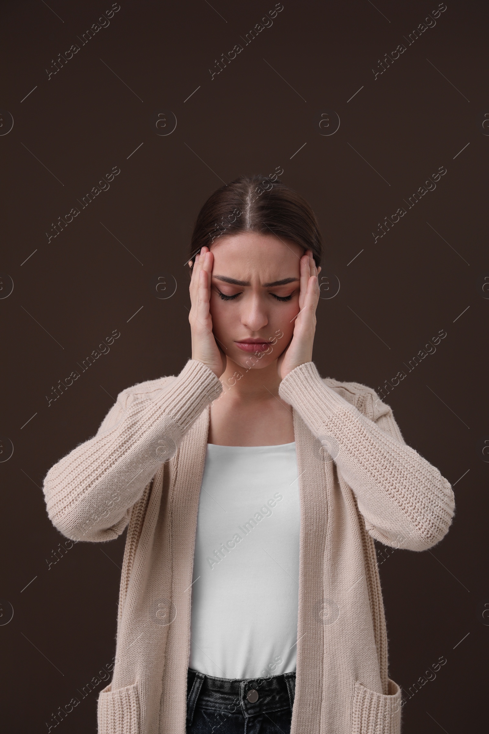 Photo of Woman suffering from headache on brown background. Cold symptoms