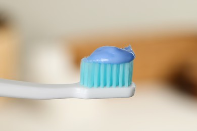 Photo of Plastic toothbrush with paste on blurred background, closeup