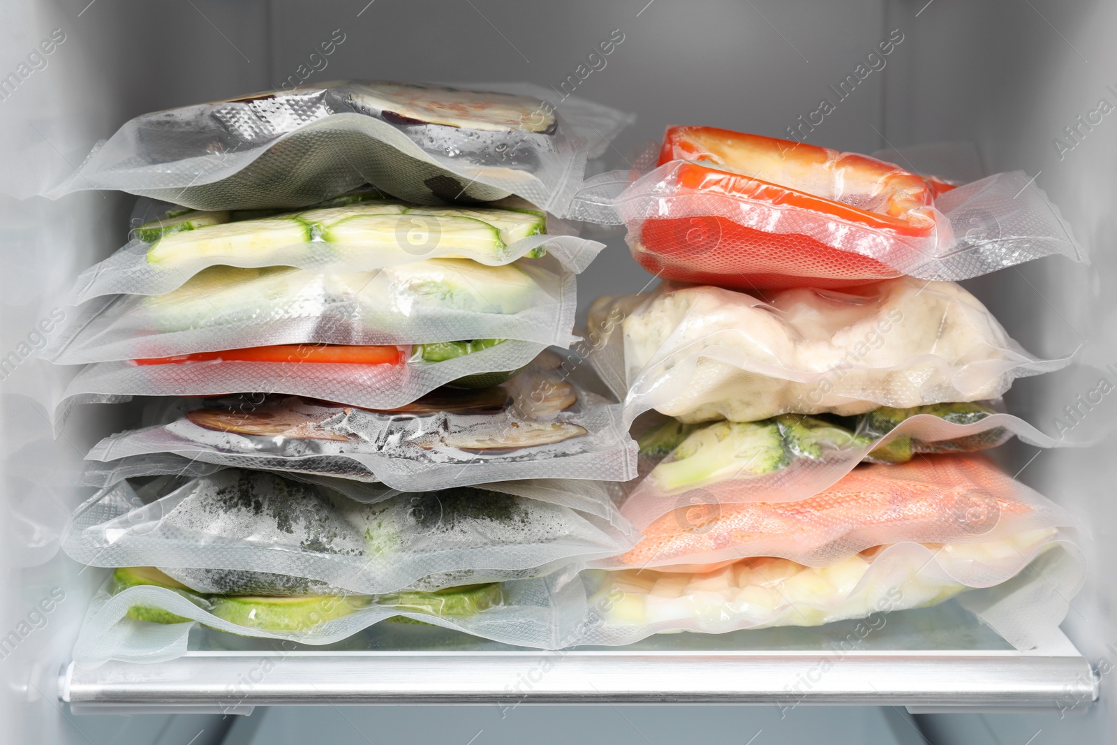 Photo of Vacuum bags with different products in fridge. Food storage