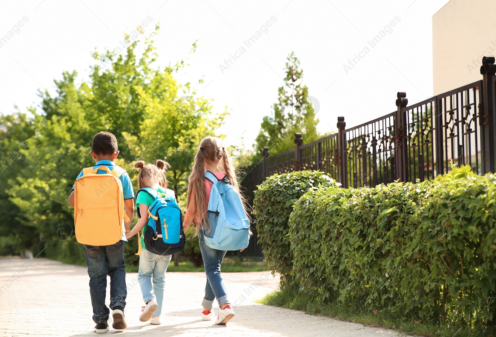 Photo of Cute little children with backpacks going to school