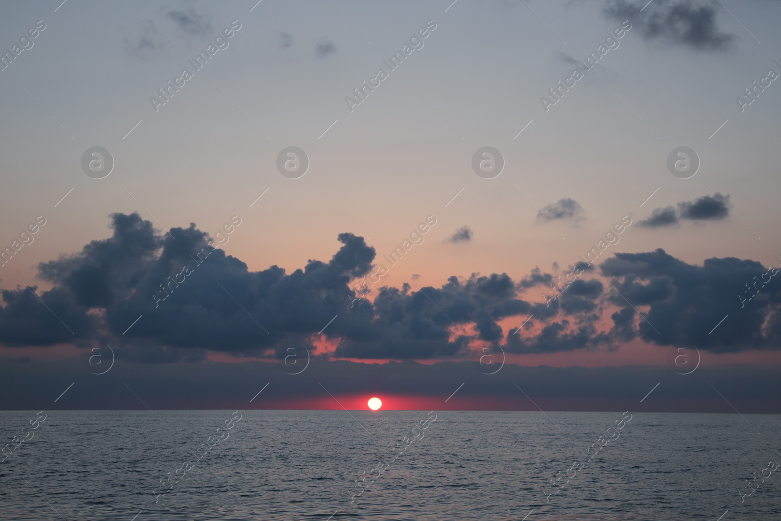 Photo of Picturesque view of beautiful sea and people parasailing at sunset