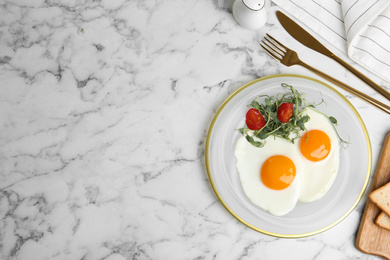 Tasty fried eggs with tomato and sprouts on white marble table, flat lay. Space for text