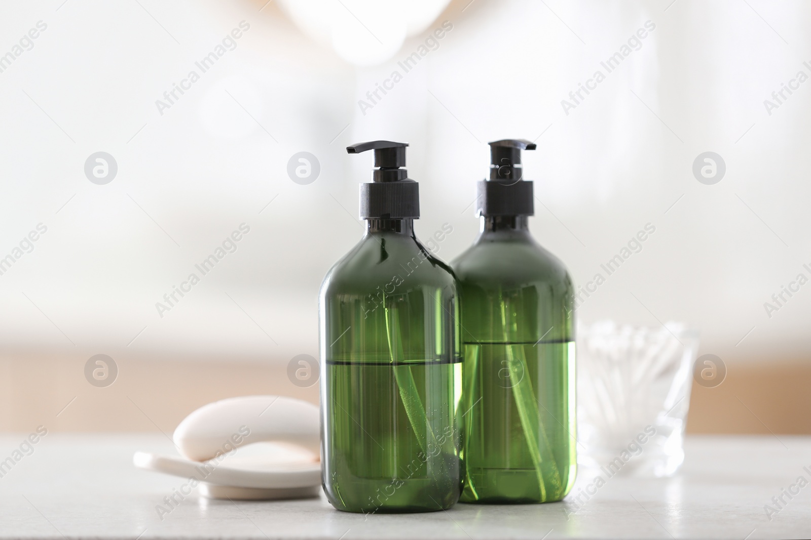 Photo of Green soap dispensers on white countertop in bathroom