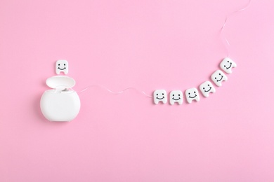 Flat lay composition with small plastic teeth and dental floss on color background