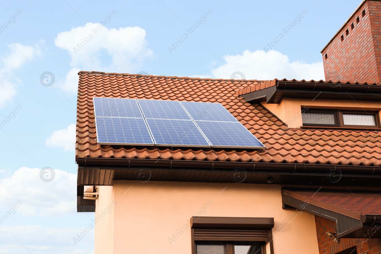 Photo of House with installed solar panels on roof. Alternative energy