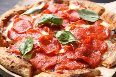 Photo of Tasty pepperoni pizza with basil on table, closeup