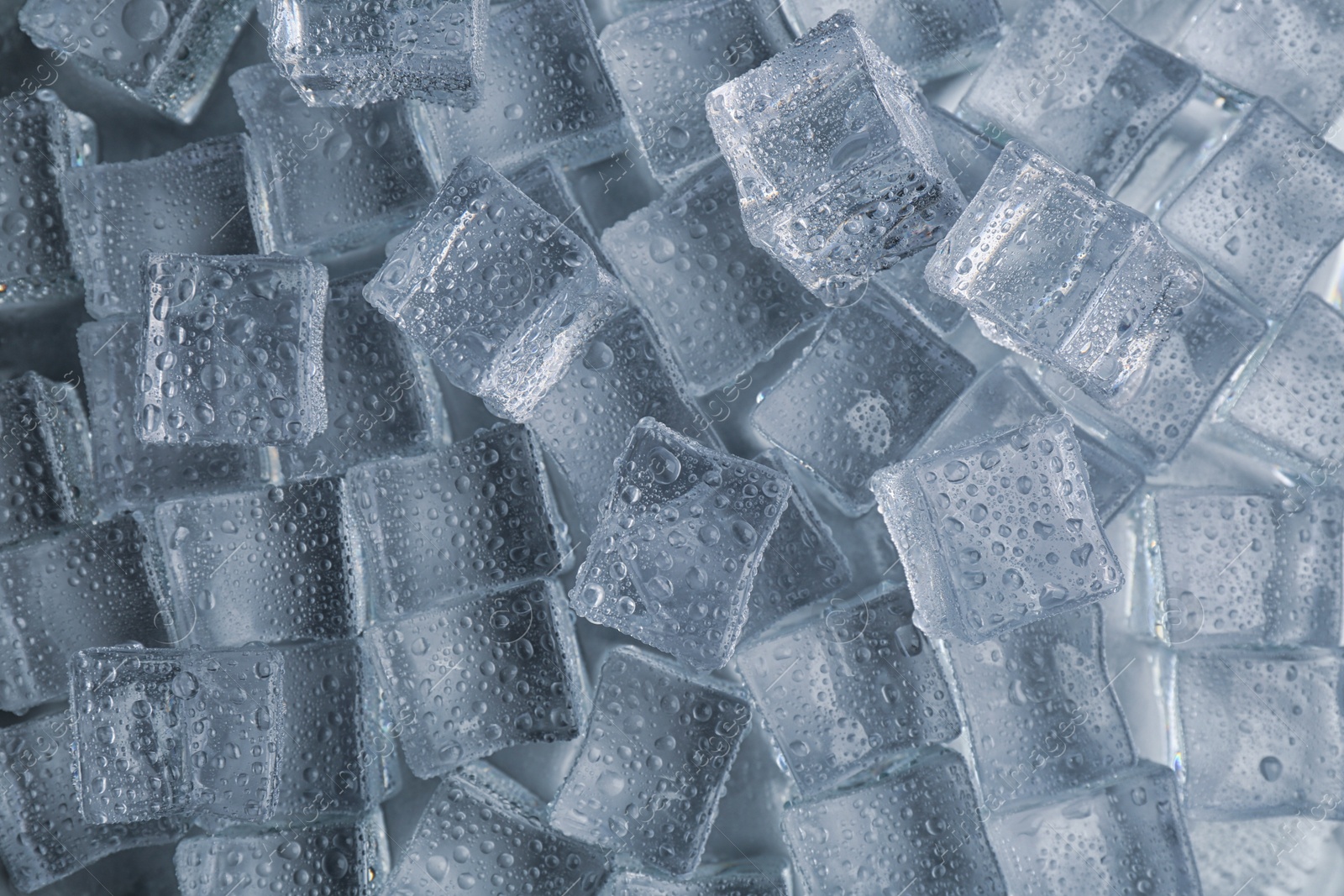 Photo of Crystal clear ice cubes with water drops as background, top view