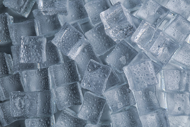 Photo of Crystal clear ice cubes with water drops as background, top view