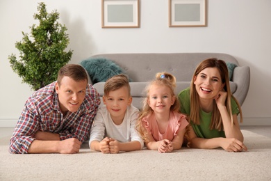 Photo of Happy family lying on cozy carpet at home