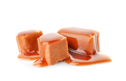 Delicious candies with caramel sauce on white background